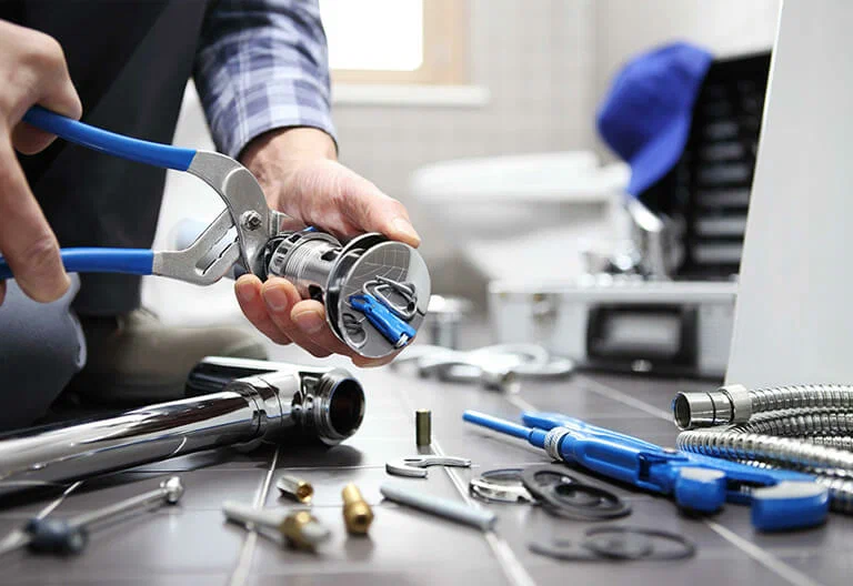 Technician repairing a plumbing fixture with professional tools in West Chester