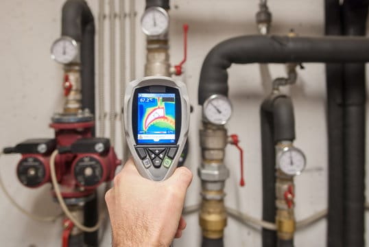 Plumber using a thermal imaging camera to inspect pipes in West Chester