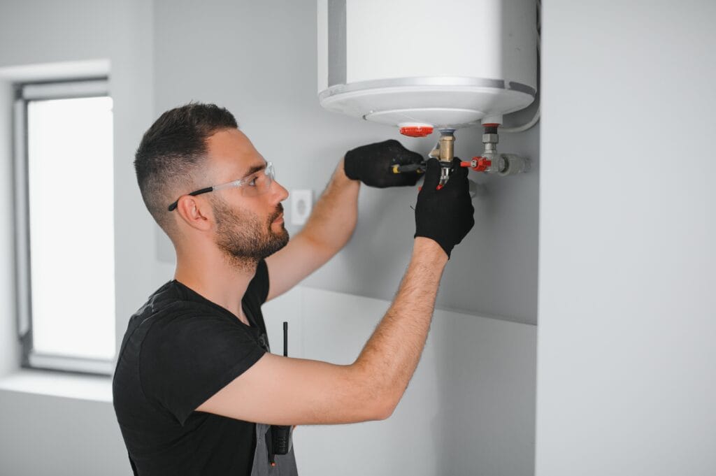 Technician performing water heater maintenance in West Chester